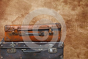 Old vintage travel suitcases over brown leather