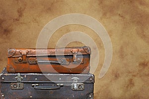 Old vintage travel suitcases over brown paper