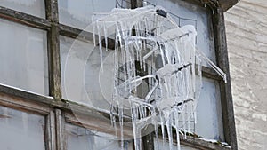 Old vintage TV antenna covered with lots of icicles in winter.