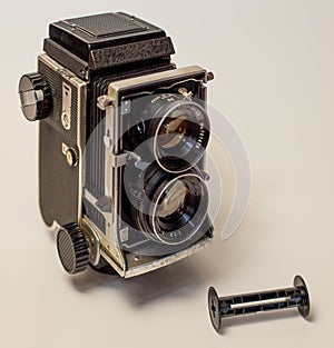 Old vintage twin-lens reflex roll-film camera isolated on a white background