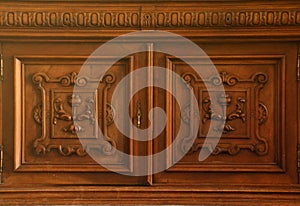 Old vintage wardrobe furniture with ornamental doors and retro colors of wooden surfaces