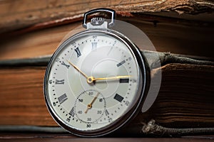 Old vintage watch on books background close up