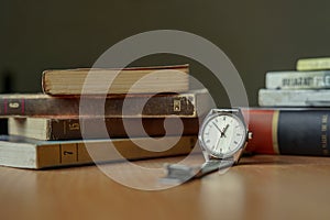 Old vintage watch and some books on a table