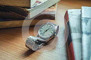 Old vintage watch and some books on a table