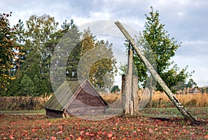 Old vintage water well in the autumn field.