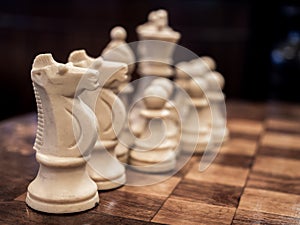 Old vintage white chess on wooden chessboard