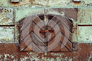 Old vintage window with closed antique wooden shutters