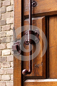 Old vintage wood door lock lock rusty brown brick wall forged wooden gate valve latch bolt catch