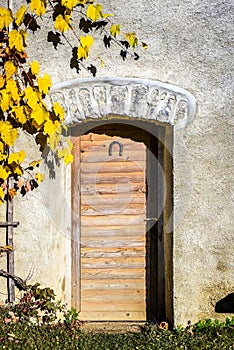 Old vintage wooden doors with horseshoe on a stone building.