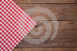 Old vintage wooden table with a red checkered tablecloth. Top view mockup.