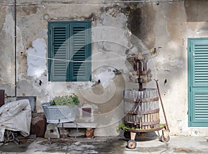 Old, vintage wooden wine press, rustic, in village street scene with other items. Bolgheri, in Tuscany, Italy. Rural
