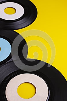 Old Vinyl 45 rpm Records on yellow background