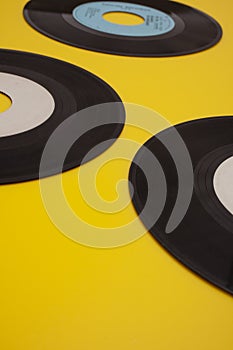 Old Vinyl 45 rpm Records on yellow background