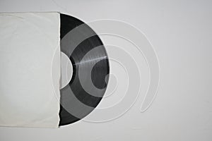 Old vinyl record in paper case on white marble background