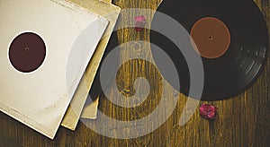 Old vinyl records discs on wooden background.