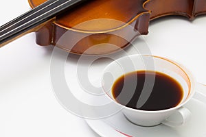 Old violin and cup of coffee on the white table