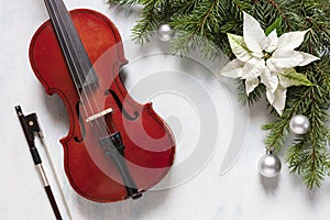 Old violin and fir-tree branches with Christmas decor and white poinsettia. Christmas, New Year\'s concept.