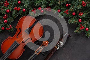 Old violin and flute with fir-tree branches with Christmas decor