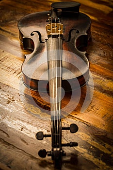 Old violin in vintage style on wood