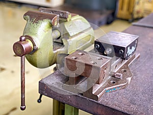 Old vise installed on table equipment in the factory