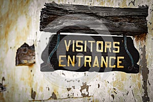 Old visitors entrance sign on wall
