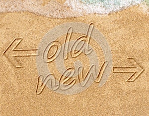 Old vs new life change concept written on sand