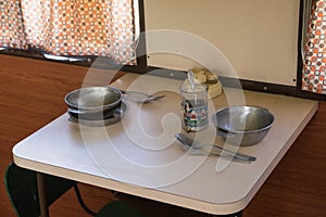 Old wagon interior. Train compartment, table, soup, spoon, glass. Railway road environment background.