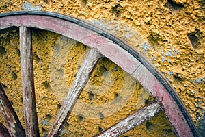 Old Wagon Wheel Leaning Against a Stucco Wall in Mexico