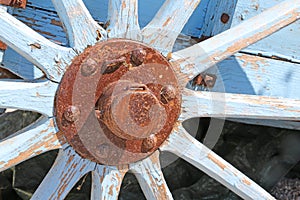 Old wagon wheel of wood with rusty hub
