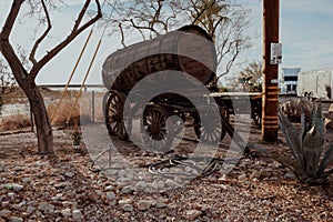 Old wagon with a wooden barrel on it, standing in the yard