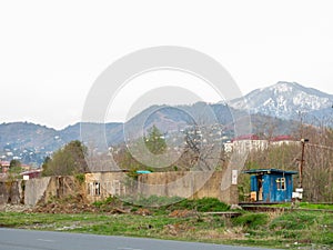 Old wall against the backdrop of mountains. Abandoned places. Forgotten infrastructure. Broken houses