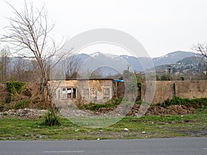 Old wall against the backdrop of mountains. Abandoned places. Forgotten infrastructure. Broken houses