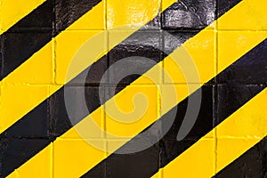 Old wall with black and yellow stripes surface. Warning or danger concept. Danger sign background.