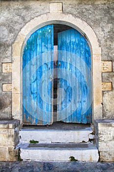 Old wall and blue wooden door, Greece