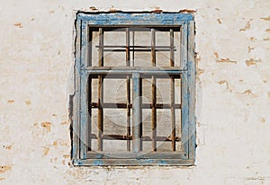 Old wall and closed wooden window with rust grille