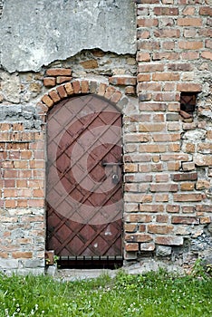 The old wall, door, mixed various bricks. Fragment of the historical building