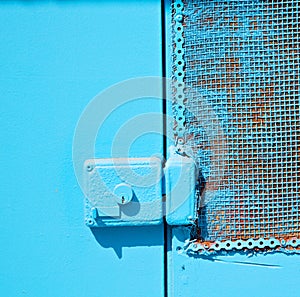 in the old wall a hinged window blue wood and rusty metal