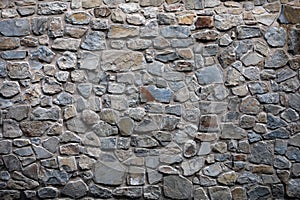 An old wall of natural material made of granite blocks