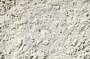 Old wall plastered with white painted mud closeup