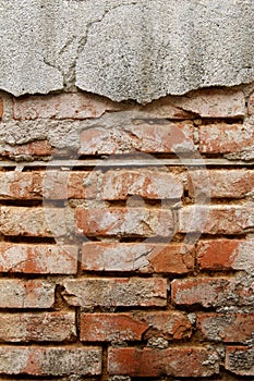 Old Wall of red bricks and damaged broken plaster, abstract background. Brick wall building