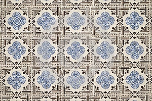 Old wall with traditional Portuguese decor tiles azulezhu in blue and brown tones on a beige background.