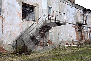 Old walls. Abandoned building. Production room. Brick building with a metal staircase