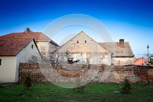 Old walls and a crumbling facade on an abandoned residential building of a farm in Ruma, Vojvodina, Serbia,