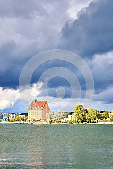 Old warehouse as a hotel on Ziegelsee in Schwerin under dramatic clouds. Mecklenburg-Western Pomerania, Germany