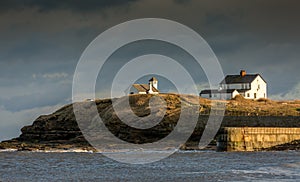 The old Watch House on the cliffs above Seaton Sluice in Northumberland, England at sunset