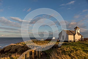 The old Watch House on the cliffs above Seaton Sluice in Northumberland, England at sunset