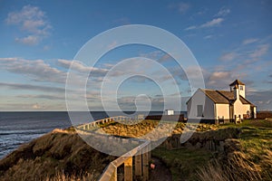 The old Watch House on the cliffs above Seaton Sluice in Northumberland, England at sunset