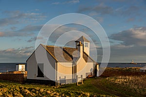 The old Watch House on the cliffs above Seaton Sluice in Northumberland, England at sunset