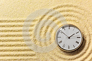 Old watch on surface of golden sand