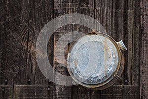 Old water canteen hanging on barn siding